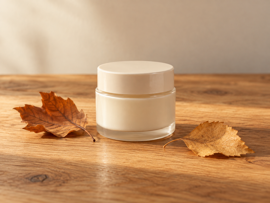 Face cream jar on a wooden table with autumn leaves