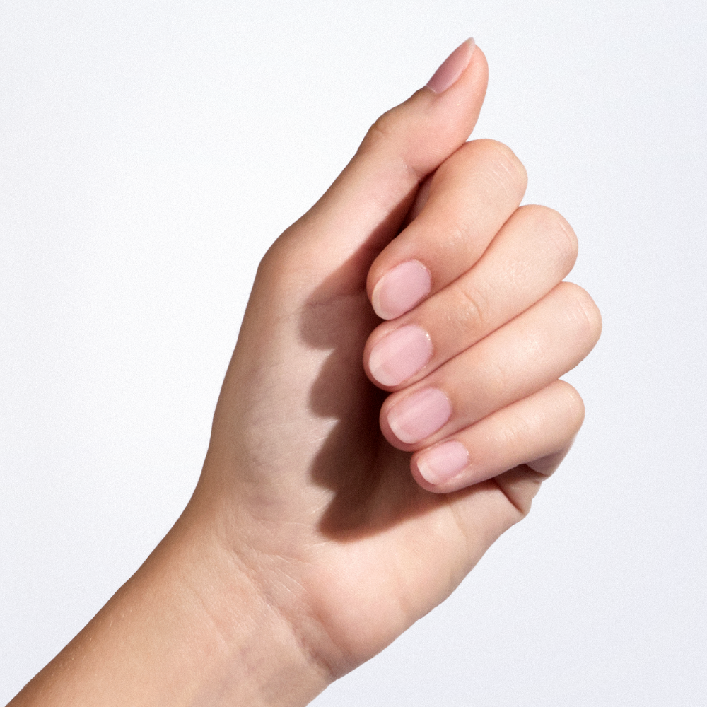 Hand with natural nails after using Eveline regenerating and hardening nail serum